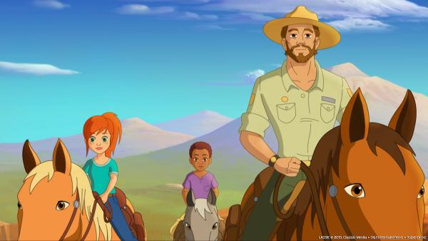 Bild 1 von 3: Zoé (l.) und Harvey (M.) verbringen gemeinsam mit Graham (r.) einen Tag unter Cowboys und helfen Wildpferde einzufangen.