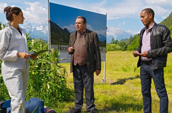Bild 1 von 6: Gustl Herzog (Komparse, liegend), der Souvenirkönig von Berchtesgaden, wird erstochen aufgefunden. Beissl (Andreas Giebel, 2. von rechts), Jerry (Peter Marton, rechts) und die \