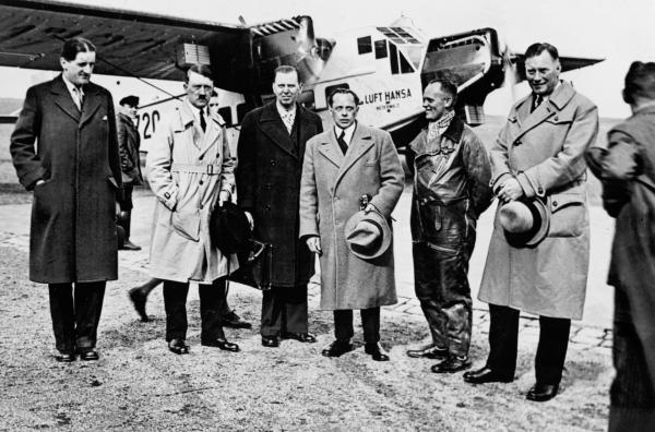 Bild 1 von 2: Adolf Hitler (vorne 2.v.l.) nutzte im Wahlkampf 1932 die Luft Hansa, um dank schneller Flüge bis zu neunmal am Tag im gesamten Reichsgebiet bei Großveranstaltungen aufzutreten.