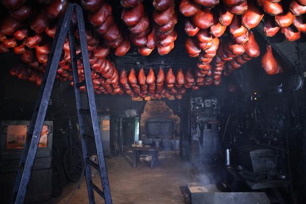 Bild 1 von 13: In der Räucherei Braasch in Harmsdorf wird nach alter Tradition das Fleisch geräuchert. Der Schinken hängt an der Decke von der Räucherkate.