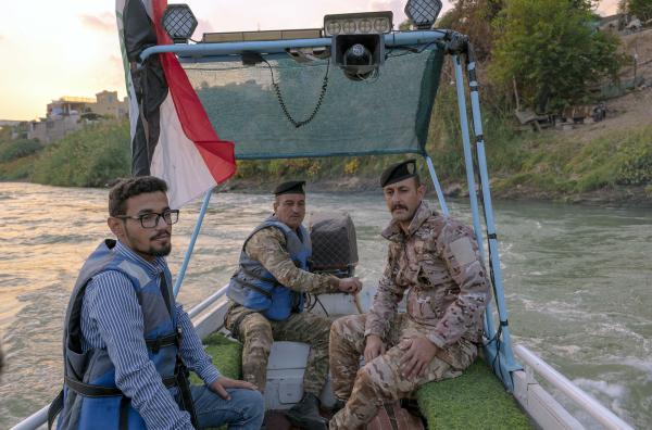 Bild 1 von 4: Khalid Bin Al Walid Omar (li.) mit Polizisten am 5. November 2024 auf dem Tigris, Qayyarah, Irak: Der Aktivist kämpft gegen die Umweltverschmutzung durch ein Ölfeld und eine Raffinerie in der Nähe seiner Heimatstadt Qayyarah.