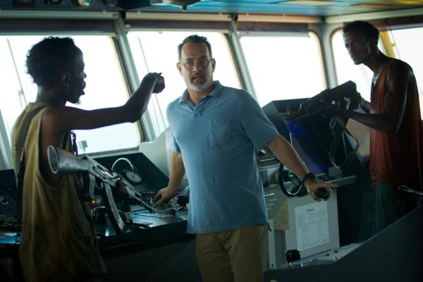 Bild 1 von 3: Mit finsteren Blicken und geübter Härte stürmen die somalischen Piraten Muse (Barkhad Abdi, l.) und Najee (Faysal Ahmed, r.) das Steuerhaus eines riesigen Frachters und bedrohen den Kapitän Richard Phillips (Tom Hanks, M.).
