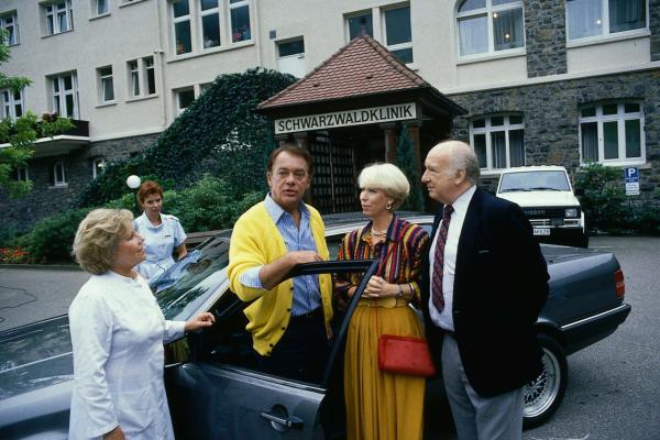 Bild 1 von 1: Bei einem zufälligen Besuch wird Prof. Brinkmann (Klausjürgen Wussow, M.) sofort von seinem Klinikpersonal umringt, die den lange Vermissten herzlich begrüßen.