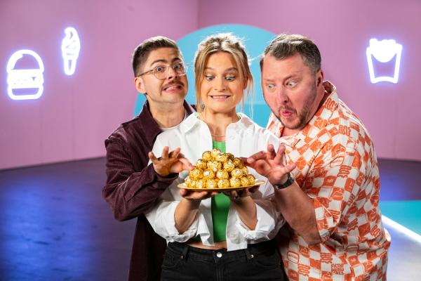 Bild 1 von 6: Die besseresser Lilly Temme (M.), Sebastian Lege (r.) und Florian Reza (l.) setzen sich in einer neuen Show für die ZDF Mediathek kritisch mit Ferrero Rocher auseinander: Was steckt wirklich in der goldenen Kugel?