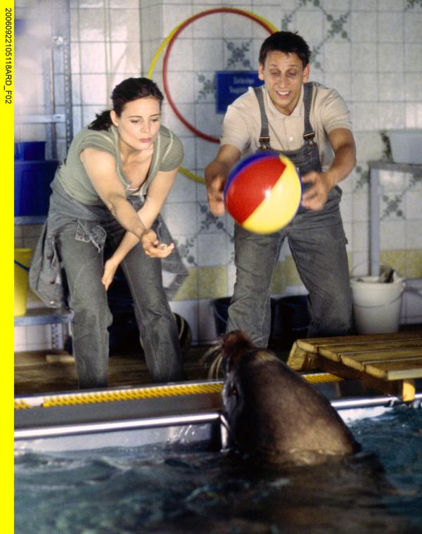 Bild 1 von 8: Wenige Stunden nach der erfolgreichen Darmoperation spielt die Robbe Olli wieder fröhlich mit Dr. Mertens (Elisabeth Lanz, links) und dem Tierpfleger Conny (Thorsten Wolf).