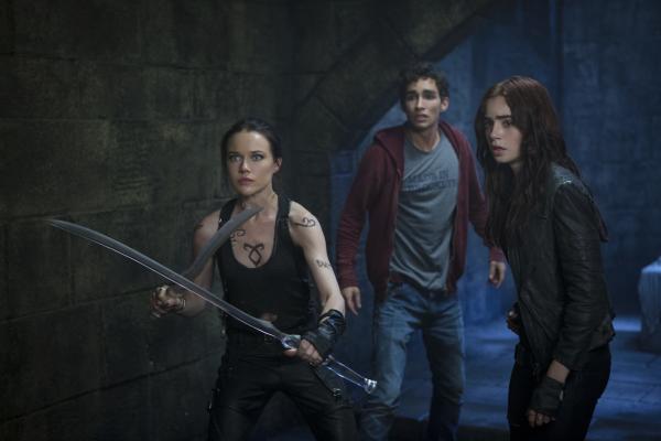Bild 1 von 22: Als Clarys (Lily Collins, r.) Mutter verschwindet, werden sie und ihr bester Freund Simon (Robert Sheehan, M.) in eine Welt katapultiert, die so gar nichts mit der ihren gemein zu haben scheint: Dämonen, Vampiere, Magier und Schattenjäger, wie die Kriegerin Isabella (Jemima West, l.) ...