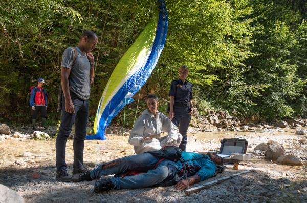 Bild 1 von 1: Der Profi-Paraglider Mike Bischoff ist in den Tod gestürzt. War es kein Unfall? Die Ermittlungen der Kommissare bestätigen zunehmend diese These. V.l.n.r. Jerry Paulsen (Peter Marton), Pathologin Sonja Bitterling (Genoveva Mayer), Caro Reiser (Sarah Thonig) und Komparsen