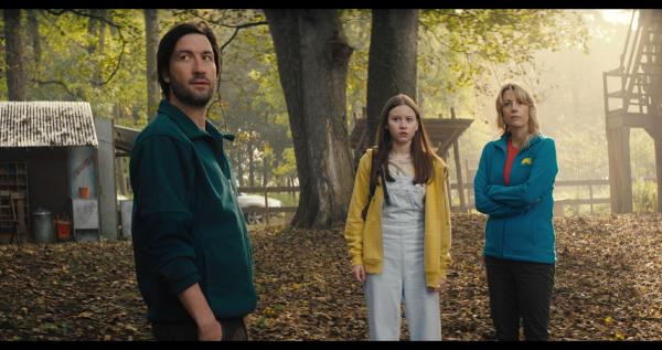 Bild 1 von 6: Daniel (Liam McMahon, l.) und Steph (Claire Goose, r.), die Besitzer des Silverpoint-Camps, nehmen Meg (Katy Byrne, M.) in Empfang. Hier im Camp, in dem alles mit der Libellen-Gruppe angefangen hatte, soll sie ihre Erinnerungen an diese Zeit wieder zurückbekommen.