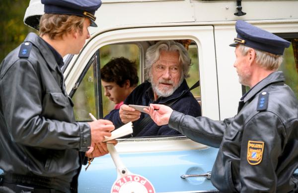 Bild 1 von 3: Jetzt wird es brenzlig: Wilhelm Schürmann (Jürgen Prochnow) und Felix (Marinus Hohmann, hinten.) werden von den Beamten Gruber (Arnd Schimkatt, li.) und Niedermeier (Wowo Habdank, re.) kontrolliert.