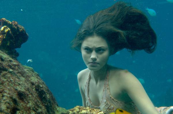 Bild 1 von 2: Cleo (Phoebe Tonkin) ist entsetzt: Sie sieht Charlotte als Meerjungfrau durchs Wasser schwimmen. Seit wann ist Charlotte auch eine Meerjungfrau?