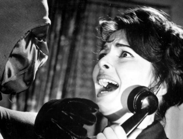 Bild 1 von 1: Valerie Howett (Karin Dor) wird von dem maskierten Bogenschützen beim Telefonat überrascht und bedroht.