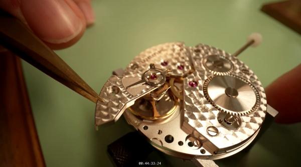 Bild 1 von 3: Unter der Pinzette entsteht millimetergenau das Herzstück einer Uhr - ein Meisterwerk aus Zahnrädern, Schrauben und feinen Gravuren.