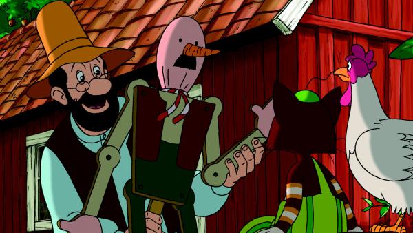 Bild 1 von 2: Pettersson zeigt Findus und der Henne Prillan seine Vogelscheuche.