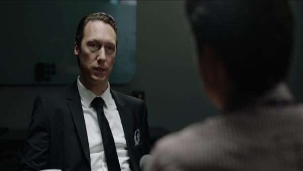 Bild 1 von 3: Adam (Simon J. Berger, l.) wird von Polizeikommissar Hartmann (Frank Kjosås, r.) verhört und der Zuhälterei sowie der Veruntreuung von Firmengeldern beschuldigt.