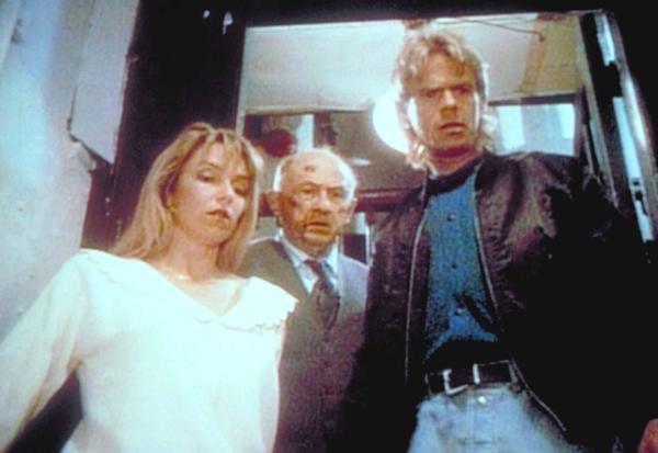 Bild 1 von 10: Maria (Brigitta Stenberg, l.), Romburg (Milton Selzer, M.) und MacGyver (Richard Dean Anderson, r.) sehen betroffen auf Weise, der die Treppen heruntergestürzt ist.