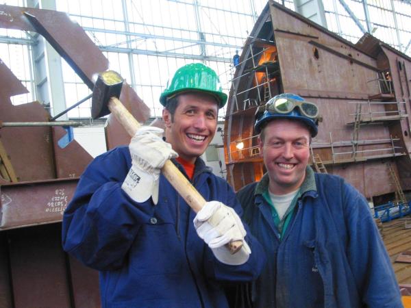 Bild 1 von 3: Zusammen mit einem Mitarbeiter der Nordseewerke erkundet Willi (links) die Emdener Schiffswerft.