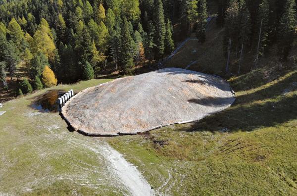 Bild 1 von 4: In St. Moritz wird zum ersten Mal Snowfarming betrieben. Durch den heißen Sommer ist der Schneehügel aus recyceltem Schnee geschmolzen.