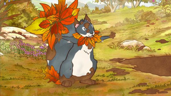 Bild 1 von 6: Das kleine Grauhörnchen springt in die Matsch-Pfütze. Dann dekoriert es sich mit Blättern, und fertig ist das Blätter-Wesen.