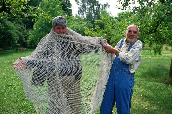 Bild 1 von 6: In diesem Netz wollte Herr Paschulke (Helmut Krauss, l.) einen Bären fangen. Peter (Peter Lustig, r.) hat große Mühe, seinen Nachbarn aus dem Gewirr zu befreien.