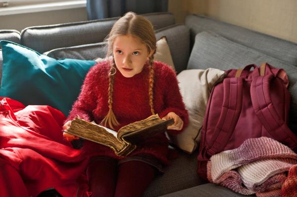 Bild 1 von 3: Paule (Chloé Heinrich) liest im geheimnisvollen Weihnachtsbuch, wie der wahre Weihnachtsmann aussieht.