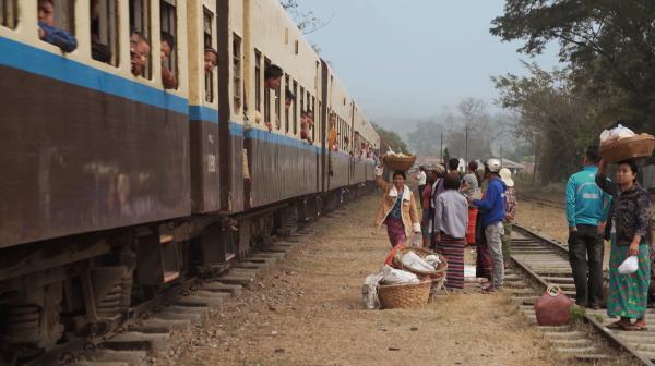 Bild 1 von 1: Fliegende Händler versorgen die Zugreisenden der Myanmar Railsways mit allerlei Köstlichkeiten.