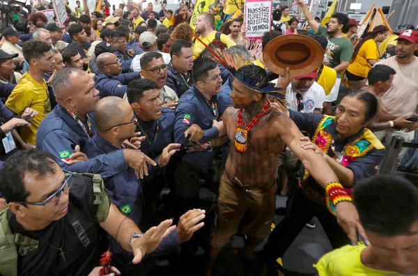 Bild 1 von 1: Ein Ureinwohner aus dem Amazonasgebiet unterbrach die streng reglementierte COP30 in Brasilien, indem er mit nacktem Oberkörper und Federkopfschmuck auftrat. Das Foto wirft die Frage auf, welchen Stellenwert diese Stimmen bei den Klimaverhandlungen haben.
