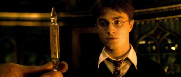 Bild 1 von 15: Daniel Radcliffe as Harry Potter staring at potion in glass container.