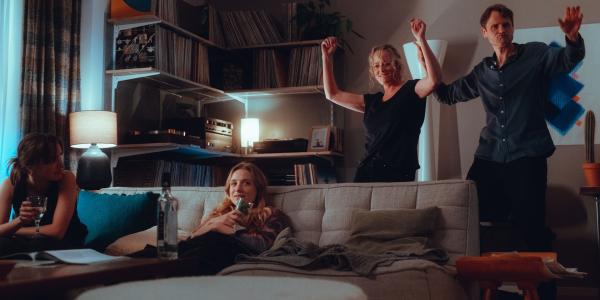 Bild 1 von 9: Von links: Zoe (Lena Klenke) und Milli (Clara Vogt) sitzen auf der Couch, während Caro (Silke Bodenbender) und Martin (Fabian Hinrichs) tanzen.
