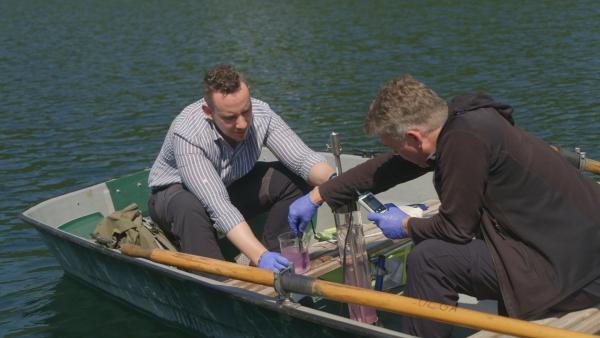 Bild 1 von 7: Die beiden Biologen Patrick Jung und Michael Lakatos untersuchen den Sauerstoffgehalt des Wassers im Alatsee in Bayern. Die rosa Färbung des Wassers ist auf uralte Mikroorganismen zurückzuführen, die in den sauerstofffreien Tiefen des Sees leben.