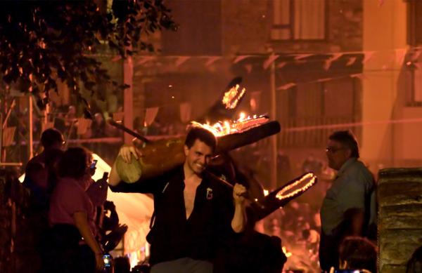 Bild 1 von 4: Beim Feuerritual zur Sommersonnenwende in Isil tragen die Einwohner brennende Baumstämme den Berg hinunter.