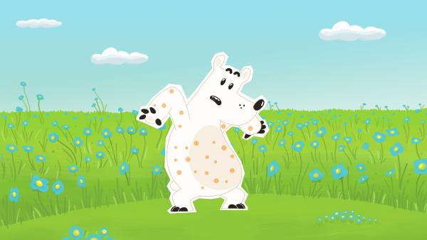 Bild 1 von 1: Als Eisbär Grumpel nach einem Nickerchen in einer Wiese aufwacht, ist er über und über mit kleinen hellbraunen Punkten bedeckt. Ob er etwa die gefährlichen und ansteckenden Bären-Masern bekommen hat?