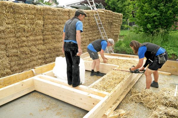 Bild 1 von 6: Hausbau mit Strohballen:überstehende Stoppel rasieren die Zimmermänner einfach ab.