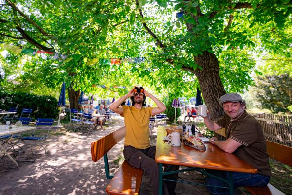 Bild 1 von 10: Der Schmidt Max (rechts) ist unterwegs in artenreichen Biergärten.  Auf seiner Entdeckungsreise bringt ihm der Ornithologe Philipp Herrmann (links) die typischen Vogelstimmen eines Biergartens bei.