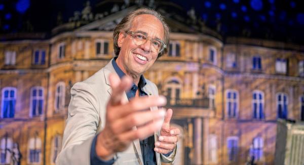 Bild 1 von 1: Christoph Sonntag steht grinsend auf der Bühne des Stuttgarter Wilhelma-Theaters und zeigt mit dem Finger in Richtung der Kamera. Im dritten Teil seines neuen Programms spricht er über Glück, Musik und Erinnerungen an die gute, alte Zeit.