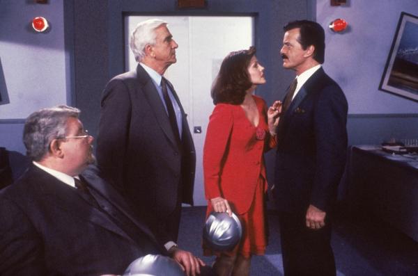 Bild 1 von 8: Der schurkische Industrielle Quentin Hapsburg (Robert Goulet, r.) lässt Dr. Meinheimer (Richard Griffiths, l.) entführen und durch einen Doppelgänger ersetzen. Doch Frank Drebin (Leslie Nielsen, 2.v.l.) und seine charmante Ex-Freundin Jane (Priscilla Presley, 2.v.r.) kommen ihm schon bald auf die Schliche ...