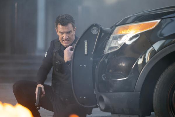 Bild 1 von 5: Officer Nolan (Nathan Fillion) gerät in Lebensgefahr, als neben ihm ein Geldtransporter explodiert und es zu einem Schusswechsel kommt.