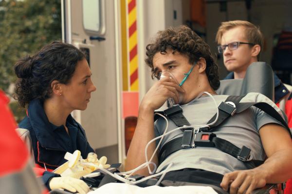 Bild 1 von 5: Dr. Sam Jordan (Hanife Sylejmani,  l.) kümmert sich um Dennis Garcia (Rafael Luis Klein-Hessling, M.). Dank seines Notrufes konnte verhindert werden, dass das komplette Restaurant seines Chefs abbrennt.