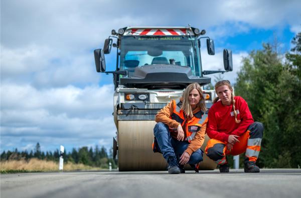 Bild 1 von 9: Reporterin Elisa Luzius (links) trifft Sally (rechts) aus Thüringen. Sie fährt in der Asphalt-Kolonne die große Walze.