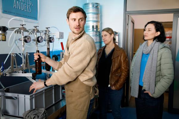 Bild 1 von 4: Tamara Meurer (Anja Pahl, M.) und Pauline Hobrecht (Agnes Decker, r.) sprechen mit Falk Kreuzer (Fre?de?ric Brossier, l.). Sein Vater hatte ihn aus dem Familienunternehmen entlassen, woraufhin er seine eigene Craft-Brauerei gründete.