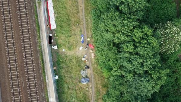 Bild 1 von 6: An der Mauer dieses Bahndamms in Berlin-Pankow findet ein Flaschensammler die Leiche einer jungen Frau. Die Ermittler sichern unter Zeitdruck den Tatort ab, da ein Gewitter droht.