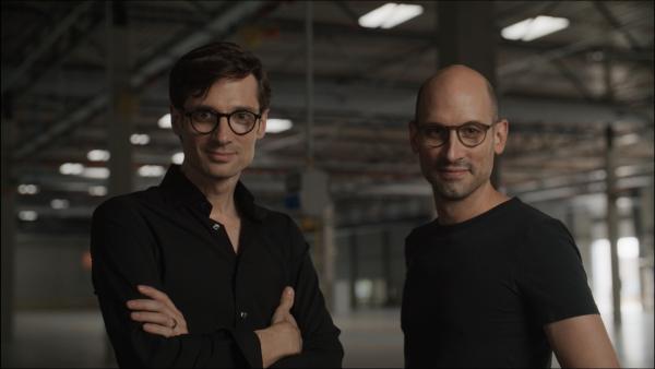 Bild 1 von 4: Daniel Schall (l.) und Sebastian Schall (r.), die beiden Gründer von Black Semiconductor, stehen in der Produktionshalle der Firma in Aachen. Hier sollen künftig die hocheffizienten Halbleiter produziert werden, für die sie eine neuartige Technologie entwickelt haben.