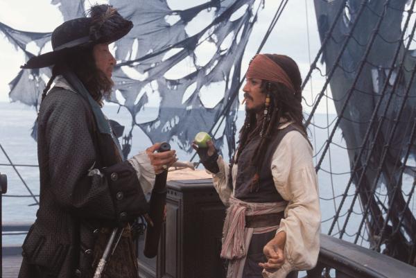 Bild 1 von 69: Kristallklar blitzt das Meerwasser in der karibischen Sonne. Hier, wo Freiheit, Abenteuer und Lebenslust förmlich in der Luft liegen, fühlt sich der verwegene und charmante Haudegen Captain Jack Sparrow (JOHNNY DEPP) zu Hause. Sein bis dahin paradiesisches Leben erhält einen jähen Dämpfer, als der durchtriebene Captain Barbossa (GEOFFREY RUSH) sein stolzes Schiff, die BLACK PEARL, in seine Gewalt bringt und mit ihr die Hafenstadt Port Royal überfällt, wo er die bildschöne Tochter des Gouverneurs, Elizabeth Swann (KEIRA KNIGHTLEY), entführt. Der junge Waffenschmied Will Turner (Orlando Bloom) mit mysteriöser Herkunft liebt besagte Tochter des Gouverneurs und möchte die Liebe seines Lebens retten - wenn es sein muss auch mithilfe des exzentrischen Captain Jack Sparrow. Zwar ist Captain Jack durch Wills Mithilfe im Gefängnis gelandet, aber die beiden Männer haben nun ein ähnliches Ziel: Will möchte Elizabeth retten und Sparrow sein Schiff \