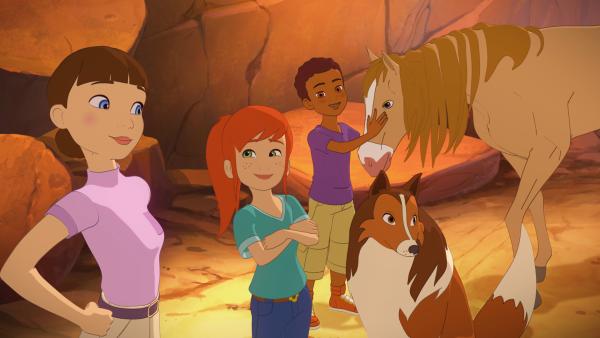 Bild 1 von 2: Zoé und Harvey freuen sich, dass sie zusammen mit Lassie der jungen Reiterin Carmen (li.) und ihrem Wildpferd helfen können.