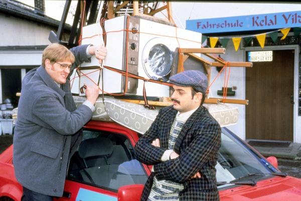 Bild 1 von 16: Der Fahrschüler Manfred Winter (Keirut Wenzel, l.) muss lernen, das Wagendach anständig zu beladen. Der Fahrlehrer Kelal Yildirim (Kaya Yanar, r.) schaut ihm kritisch dabei zu.