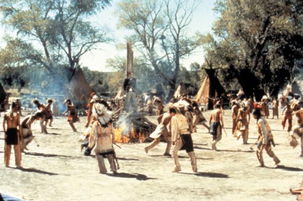 Bild 1 von 11: Full shot of Cantinflas as Passepartout tied to a stake while American Indians dance around him.