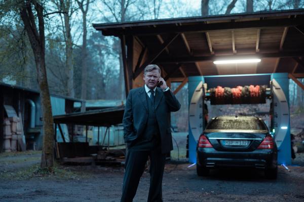 Bild 1 von 9: Bernd Hausner (Justus von Dohnányi) ist am Telefon während er sein Auto in der eigenen Waschstraße wäscht.