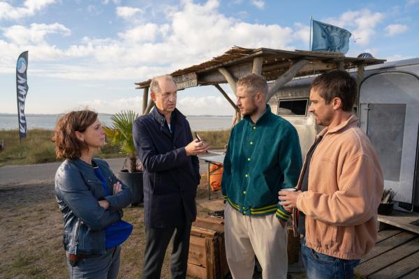 Bild 1 von 5: Carl Sievers (Peter Heinrich Brix, 2.v.l.) und Ina Behrendsen (Julia Brendler, l.) können sich nicht vorstellen, dass die beiden Kite-Surfer Tom Greiner (Anton Rubtsov, 2.v.r.) und Mats Dreyer (Nico Rogner, r.) den toten Pablo Hernandez, einen ehemaligen spanischen Profi-Kiter, nicht kennen.