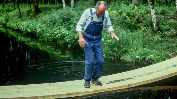 Bild 1 von 1: Peter Lustig (Peter Lustig) will eine Brücke über den Bach bauen - welche Konstruktion ist stabil und bringt ihn sicher ans andere Ufer?