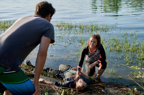 Bild 1 von 1: Das morgendliche Stand-up-Paddling von Jakob Frings (Max König, links) und Julia Demmler (Wendy Güntensperger, rechts) in der Liebesbucht findet ein jähes Ende, als Julia einen leblosen Körper am Ufer des Bodensees entdeckt.