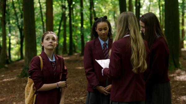 Bild 1 von 6: Addie (Lola Blue, l.) und ihre drei Klassenkameradinnen - Audrey (Eve Midgley), Emily (Grace Wood) und Jenna (Evie Elgie, v.2.v.l.n.r.) - machen zum Unterrichtsthema Hexen und Hexenverfolgung einen Ausflug in den Wald.